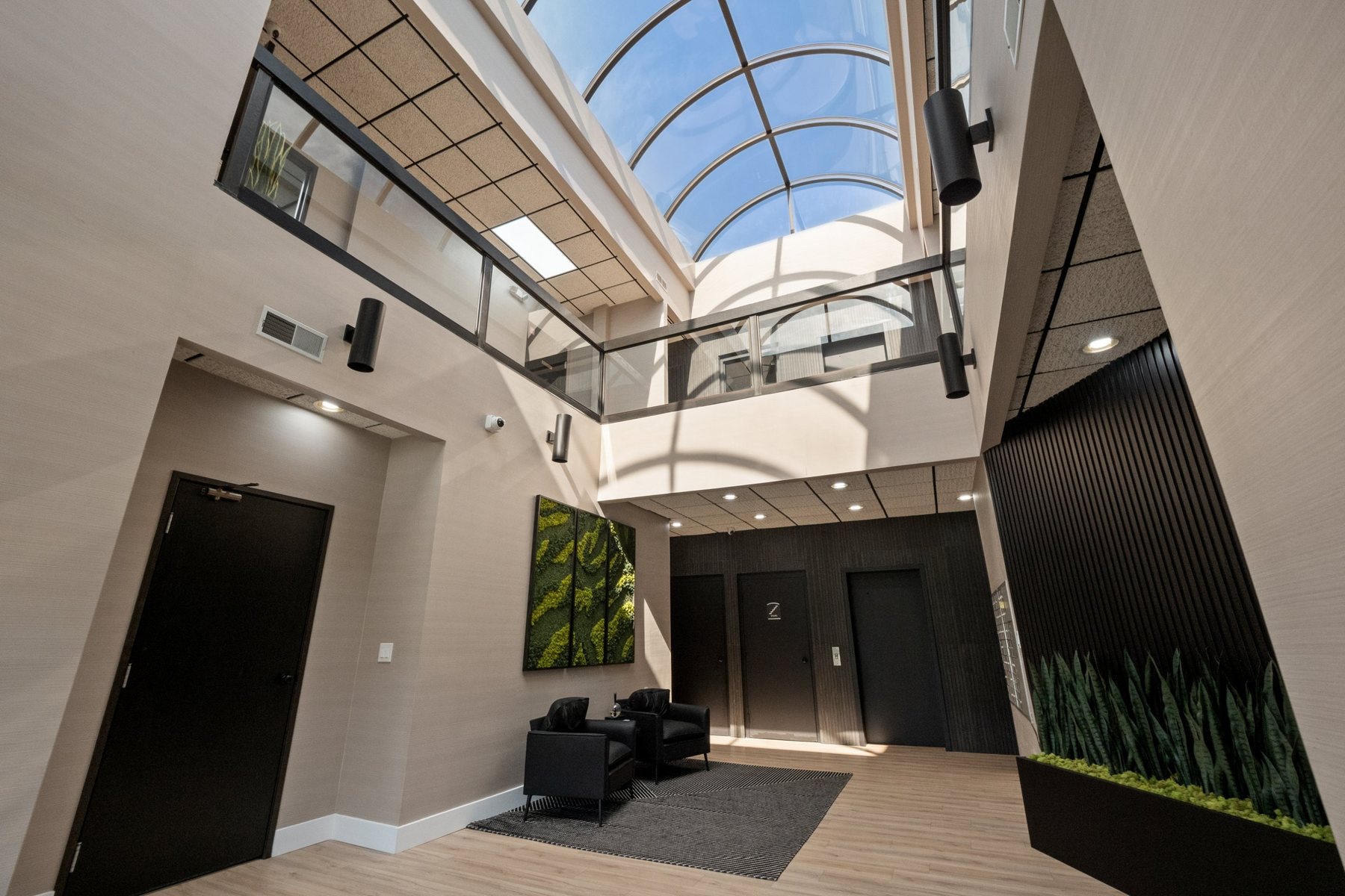 Arched glass skylight over the two-story lobby with glass balcony railing
