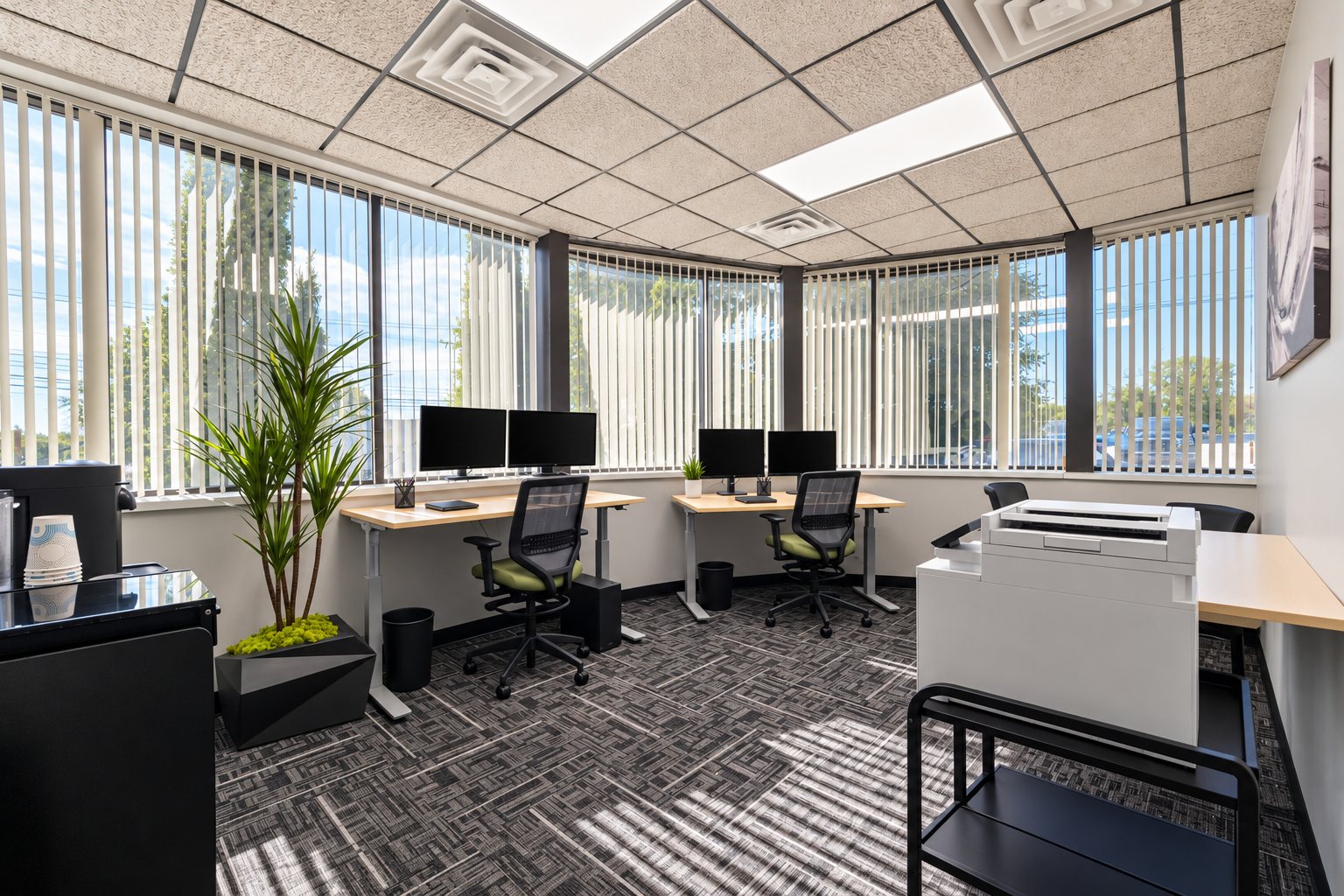 Bright corner window private office at Z Novi Commons with wraparound windows, sit-stand desks and dual monitors