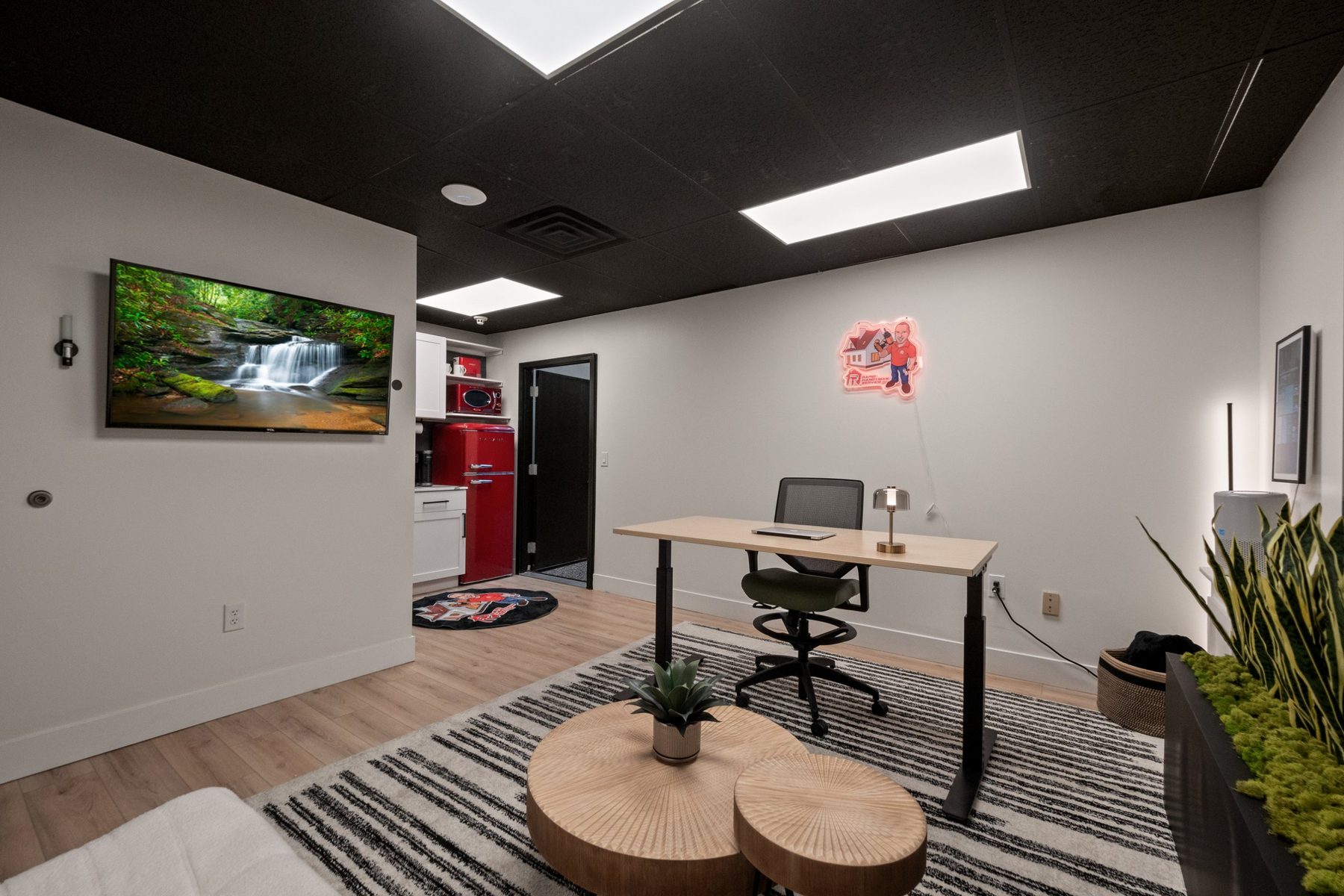 Finished office inside a warehouse suite with sit-stand desk, lounge area and kitchenette