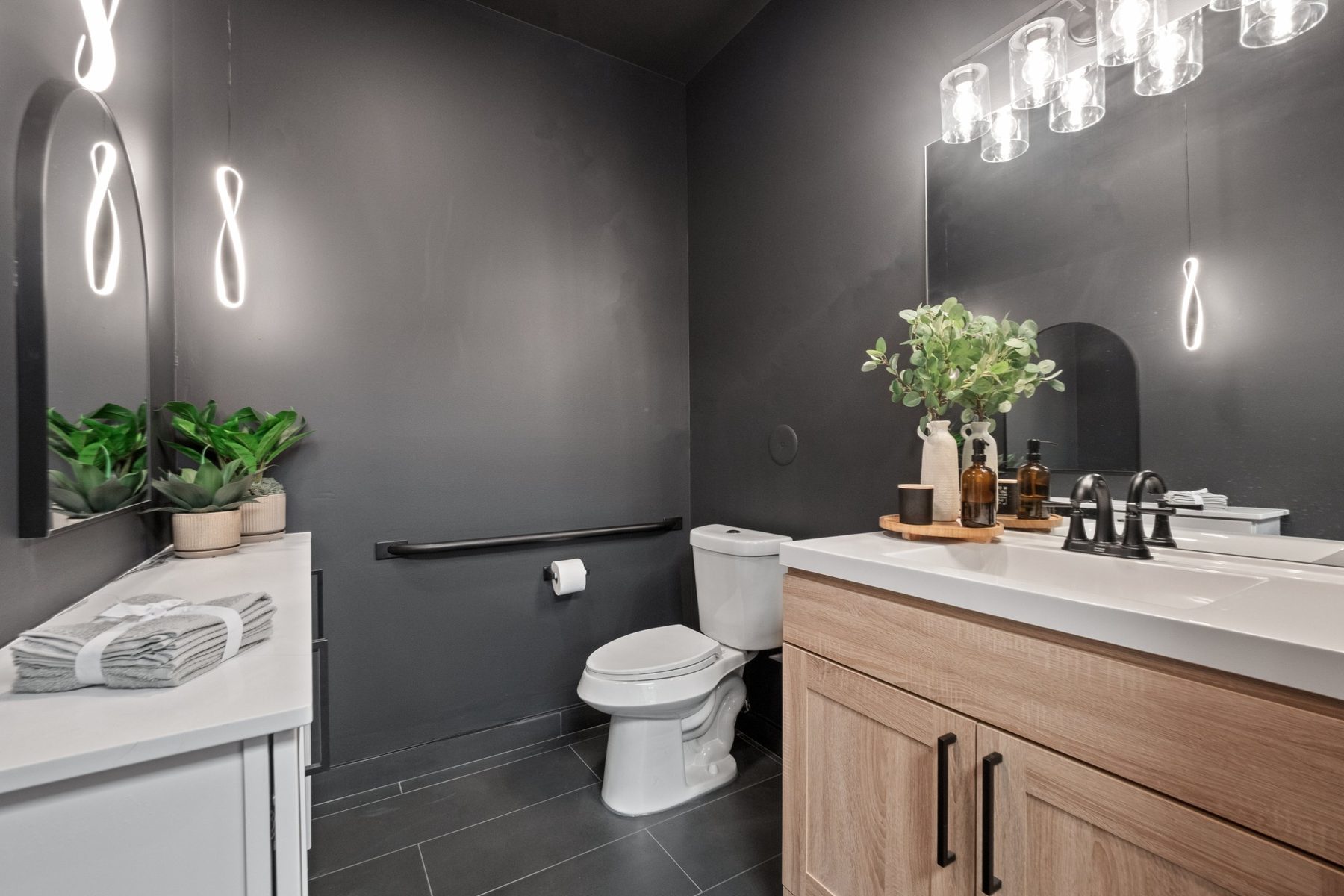 Private bathroom inside a warehouse suite with vanity, grab bar and tile floor