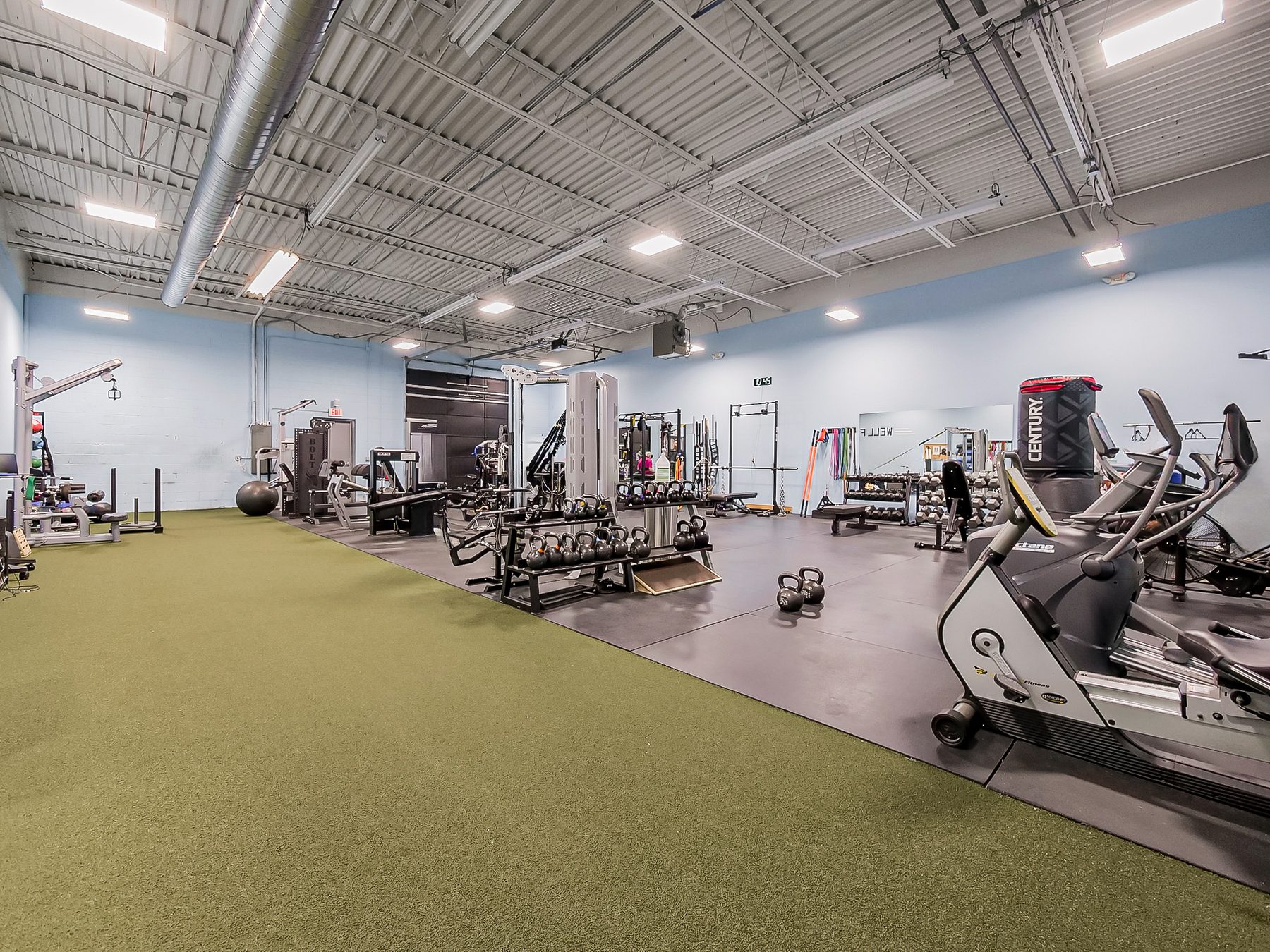 Warehouse suite built out as a fitness training studio with turf and strength equipment