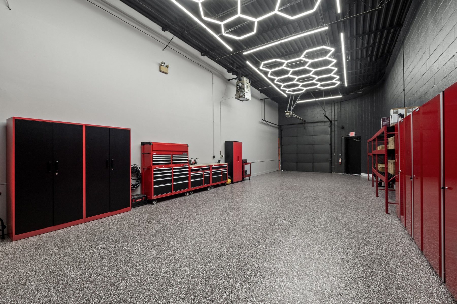 Warehouse suite with electric drive-in door, man door and storage cabinets